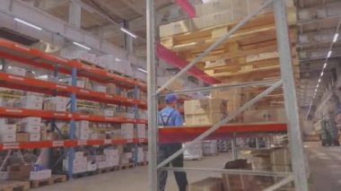 Depoya bir adam giriyor. Adam depoda sıra sıra yürüyor.