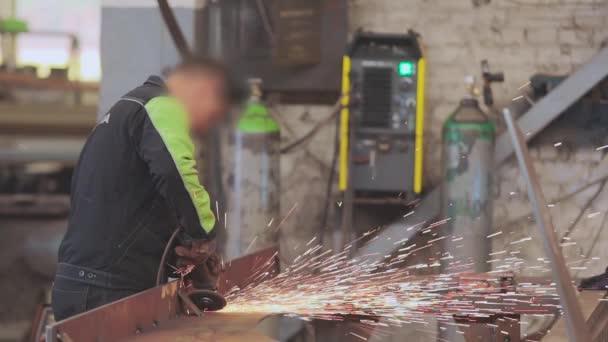 Os homens executam o trabalho do metal em uma oficina, faíscas brilhantes de uma ferramenta de trabalho — Vídeo de Stock