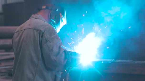 The welder collects a metal part. The welder works at the factory. Metal structure welding — Stock Video