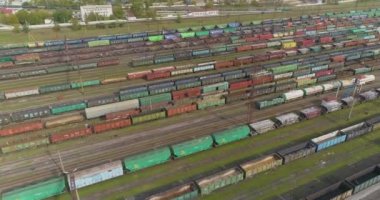 Çok sayıda yük treninin üzerinden uçun. Büyük bir kavşakta birçok tren var. Trenler demiryolu kavşağında duruyor.