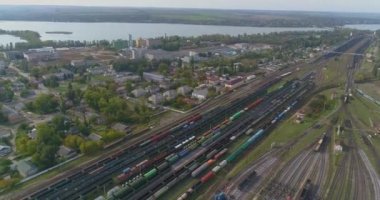 Büyük demiryolu kavşağı hava manzaralı. Tren istasyonunda bir sürü tren var. Çok sayıda demiryolu hattı ve yük treni olan bir depo.