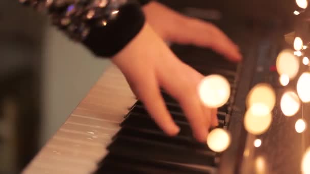 Primo piano delle mani che suonano il sintetizzatore. La ragazza suona il sintetizzatore. Sintetizzatore con decorazioni natalizie primo piano — Video Stock