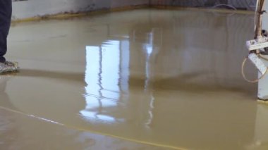İnşaatçı kendi kendine döşeme yapıyor. İnşaat alanında çalışan bir inşaat işçisi. Kendi seviyesini yükselten bir zemin oluşturma süreci