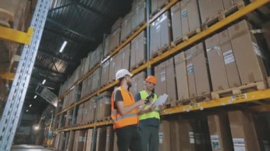 Fabrika deposunda mühendisler. Bir depoda iki işçi iş hakkında konuşuyor..