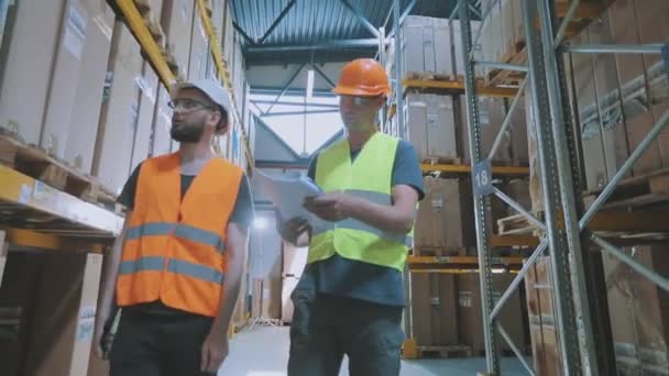 Μηχανικοί σε μια αποθήκη εργοστασίου. Δύο εργάτες σε μια αποθήκη συζητούν για δουλειά.. — Αρχείο Βίντεο