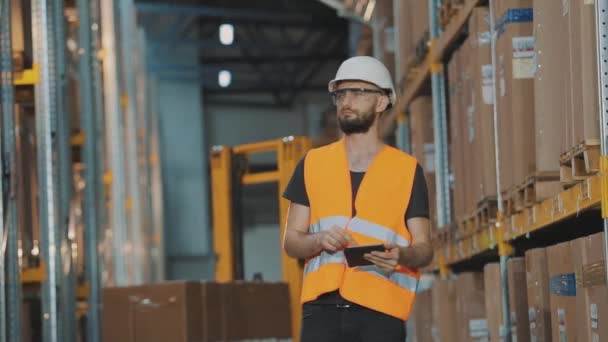 倉庫にタブレットを持っているマネージャーが商品をチェックします。大規模工場の倉庫管理者. — ストック動画