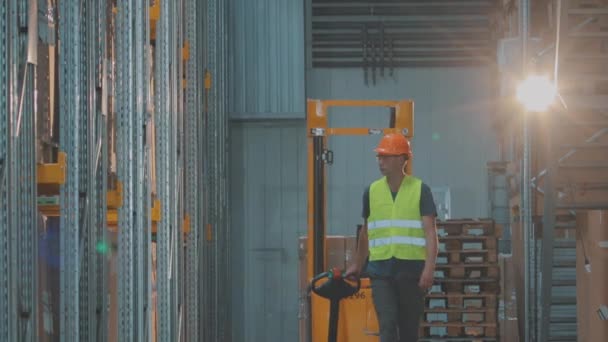 Un hombre atraviesa un almacén. Un trabajador camina por un almacén moderno en cámara lenta — Vídeo de stock