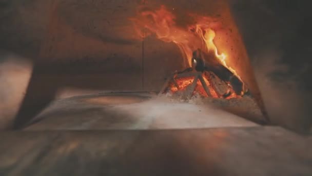 Egy fatüzelésű tűzhely, egy fatüzelésű kályha, fatüzelésű tűzhely belsejében égő rönkök. — Stock videók