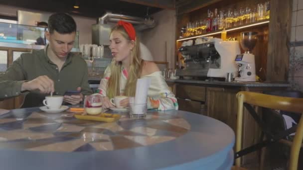Um tipo com uma rapariga num encontro num café. Casal jovem em um encontro — Vídeo de Stock