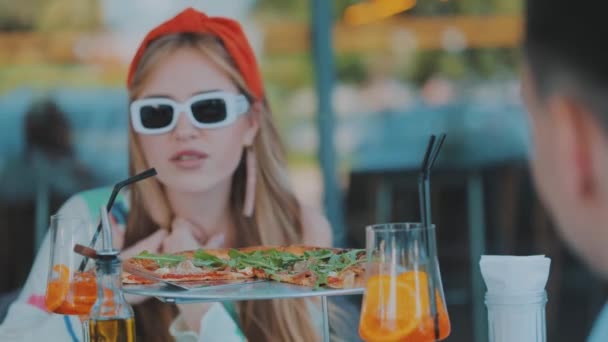 Close-up pizza, pizza e coquetel em uma mesa em um restaurante uma jovem no fundo — Vídeo de Stock