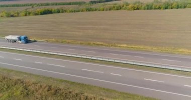 Kamyon uzun, düz bir yol boyunca gider. Kamyon yol boyunca gidiyor, doğa etrafta. Vagon, İHA ateşi altında yol boyunca gidiyor.