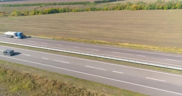 Kamyon tarlaların üst manzarası boyunca gider. Kamyon güneşli havada tarlalar boyunca sürer. Güzel bir yolda kamyon sürüyor. — Stok video