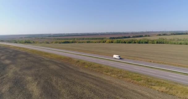 O caminhão dirige na estrada, campos no fundo. O caminhão dirige ao longo da estrada no meio dos campos agrícolas vista superior. — Vídeo de Stock