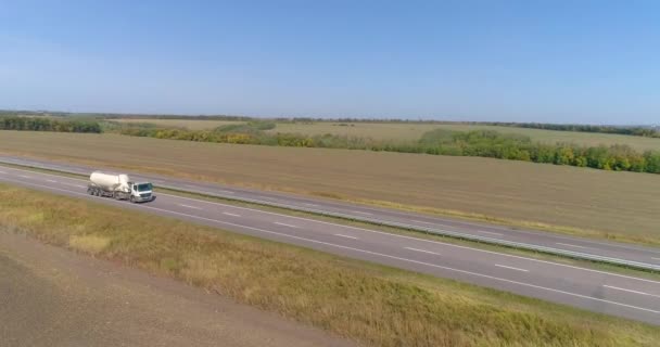 En vit vagn kör längs motorvägen i bra väder. Lastbilen kör längs terssan i soligt väder. Vagnen kör längs en vacker väg — Stockvideo