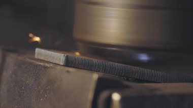 Metal bir parçayı makinede öğütmek, metal bir parçadan çıkan parlak kıvılcımlar. Metal bir parçayı makinelemekten kıvılcımlar çıkıyor
