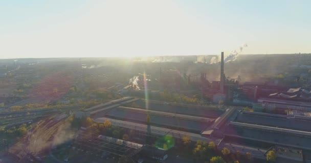 Metallurgische fabriek bij zonsopgang bovenaanzicht. Gezicht vanuit de industriële zone. Rook uit de schoorsteen van een fabriek bij zonsondergang vanuit de lucht — Stockvideo