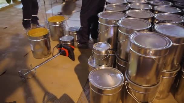 Barriles brillantes con suelo autonivelante. Pintar latas en un sitio de construcción. Tambores metálicos en una obra de construcción — Vídeos de Stock