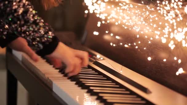 Zbliżenie rąk grających na syntezatorze. Dziewczyna gra na syntezatorze. Syntezator z dekoracjami świątecznymi zbliżenie — Wideo stockowe