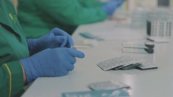 Factory workers wearing masks. work during a pandemic. Women pack pills in a package. Factory workers wearing masks. work during a pandemic — Stock Video