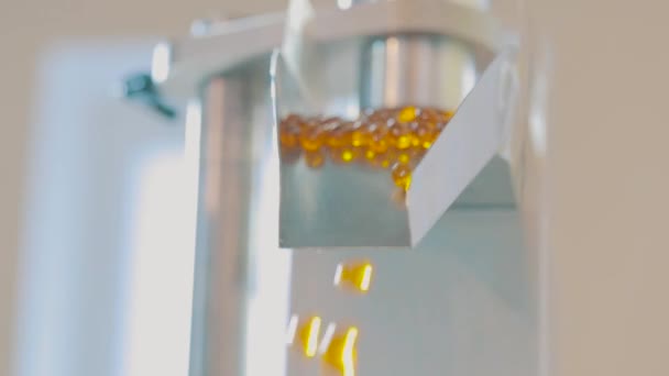 Productie van geneesmiddelen en drugs. Gelatine capsules morsen uit de pillen machine. Arge aantal gelatinecapsules — Stockvideo