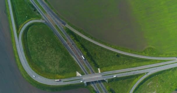 Samochody jadą autostradą, widok z góry. Ruch wymiany górny widok. Latanie nad skrzyżowaniem dróg Samochody jadą autostradą poza miastem — Wideo stockowe