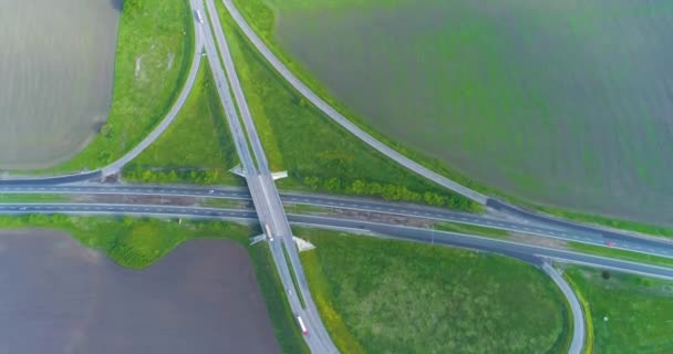 Transportowa wymiana na autostradzie. Duża droga z widokiem na góry samochodów przy dobrej pogodzie. Samochody jadą autostradą poza miastem — Wideo stockowe