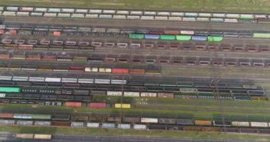 Renkli trenler büyük bir tren istasyonunda duruyor. Büyük tren deposu. Demiryolu kavşağı çok sayıda demiryolu manzaralı.