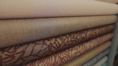 Kalıplı duvar kâğıdı. Duvar kağıdı örnekleriyle birlikte dükkanda duruyor. Yeni örneklerle ayakta duruyor. Duvar kağıdıyla yuvarlanıyor. Yakın çekim.