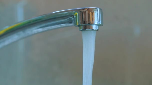 El agua del grifo fluye desde el grifo. Agua potable en el grifo. Grifo en la cocina de cerca. Primer plano del mezclador — Vídeos de Stock