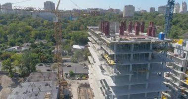 Bir konut kompleksinin inşaatı. Çok katlı bir bina havadan görüntüsü inşa ediliyor. Bir apartmanın inşaat sahasına yakın bir yerde.