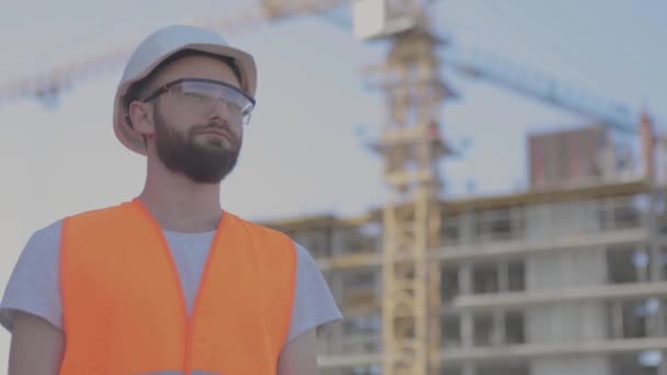 Un joven ingeniero mira de cerca la cámara. Ingeniero en Stryke. El constructor mira a la cámara — Vídeos de Stock