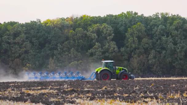 Nowoczesny traktor zaorał pole. Zielony traktor zaorał pole. Ciągnik w terenie. — Wideo stockowe