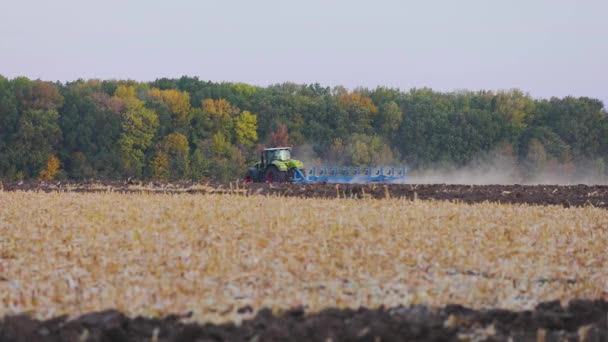 Moderne tractor werkt in het veld. Verwerking van het veld met een tractor. De tractor verwerkt het veld. Tractorploegen - Landbouwsector — Stockvideo