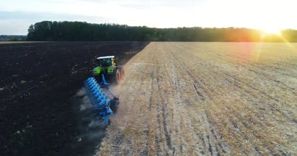 Le tracteur laboure le champ par le haut. Le tracteur travaille sur le terrain dans la soirée. Vue depuis le drone. tracteur moderne laboure le champ — Video
