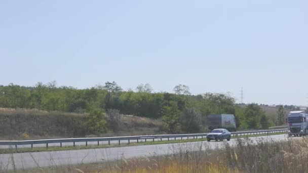 El camión conduce por la carretera alrededor de los campos y árboles. El camión está conduciendo por la carretera. — Vídeos de Stock