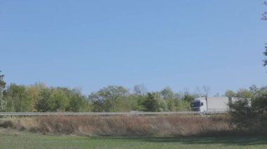Vagon yazın güzel bir yol boyunca sürer. Bir araba mavi gökyüzüne doğru yol alır