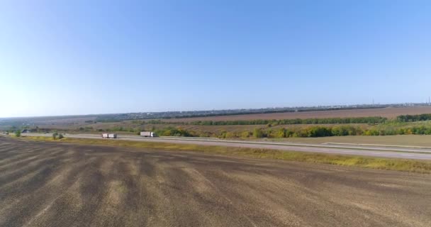 O caminhão dirige na estrada, campos no fundo. Transporte de mercadorias por caminhão. O caminhão dirige ao longo da estrada no meio dos campos agrícolas vista superior. — Vídeo de Stock