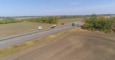 Vagon drone saldırısı boyunca sürüyor. Kamyon yol boyunca gidiyor, doğa etrafta. Kamyon uzun, düz bir yolda gidiyor..