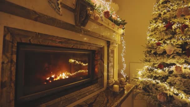 Julinredning i ett modernt hus. Vacker nyårsinredning med julgran och eldstad.Mysig julinredning — Stockvideo