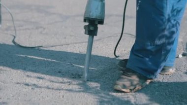 Kaya matkabı asfaltı yok eder. Yol yakın plan çalışır. Kaya matkabı yakın. Kaya matkabıyla asfalt yıkımı