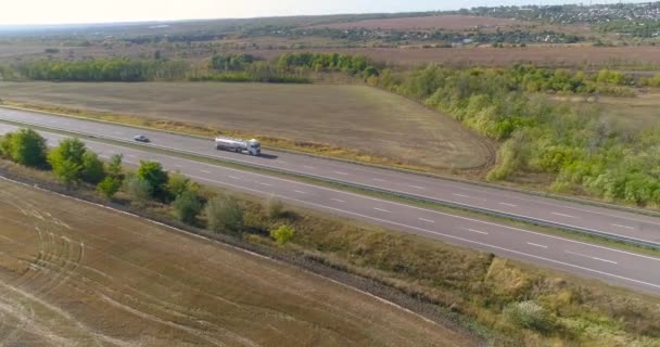 Fehér üzemanyag teherautó vezet az autópályán, üzemanyag teherautó mozog az autópályán napsütéses időben — Stock videók