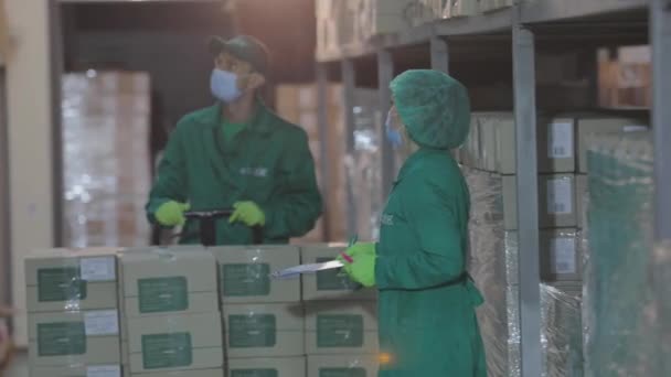 Magazzino in una fabbrica farmaceutica. Lavoratori in un magazzino con delle maschere. Persone in maschera in un magazzino moderno. — Video Stock