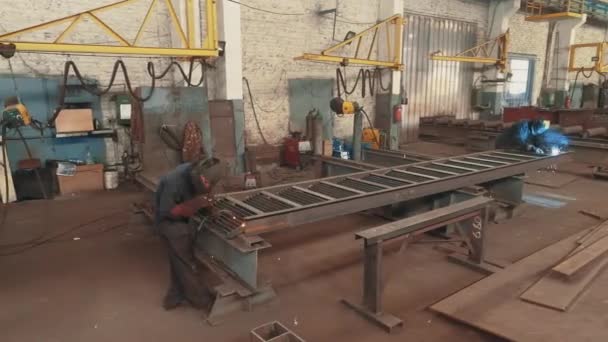 Taller para el montaje de estructuras metálicas. Soldadores soldar la construcción de metal. Fabricación de estructuras metálicas — Vídeos de Stock