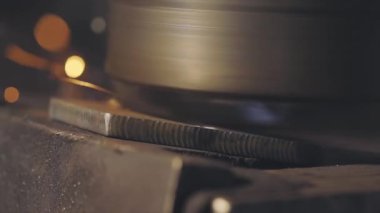 Metal parçasından parlak kıvılcımlar çıkıyor. Metal parçaları makinelemekten kıvılcımlar çıkıyor. Metal bir parçayı makinede öğütmek.