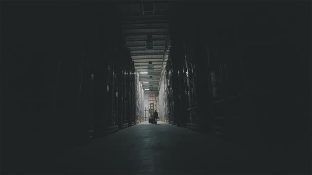 De manhã, na fábrica, um homem entra pela luz do armazém e liga-se. Ligar a iluminação em um armazém de fábrica — Vídeo de Stock