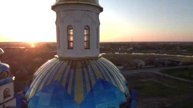 Gün batımında kilisenin üzerinden uç. Güzel bir ortodoks kilise drone manzarası. Gün batımında güzel bir kilise. Ortodoks Kilisesi