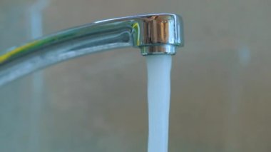 Muslukta su içmek. Musluktan musluk suyu akar. Mutfağa yakın çekim musluğu. Karıştırıcı yakın plan