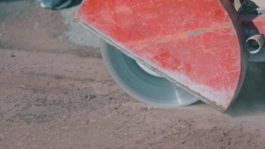 Yol çalışıyor. Yol testereyle çalışıyor. İşçi testereyle asfalt kesiyor