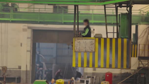 Workflow in a factory, beam crane in a factory, a woman controls a beam crane — Stock Video