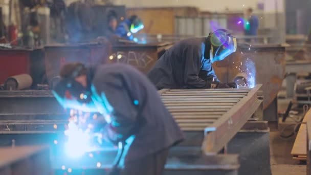 Werksschweißer. Ein Arbeiter in einer Fabrik schweißt eine Metallkonstruktion. — Stockvideo